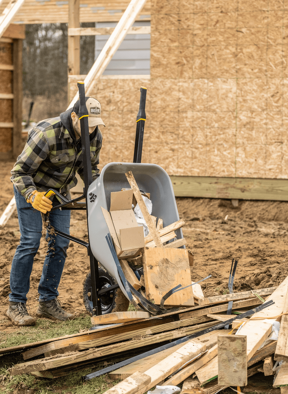 Guy dumping wood out of the 6 CU Wheelbarrow